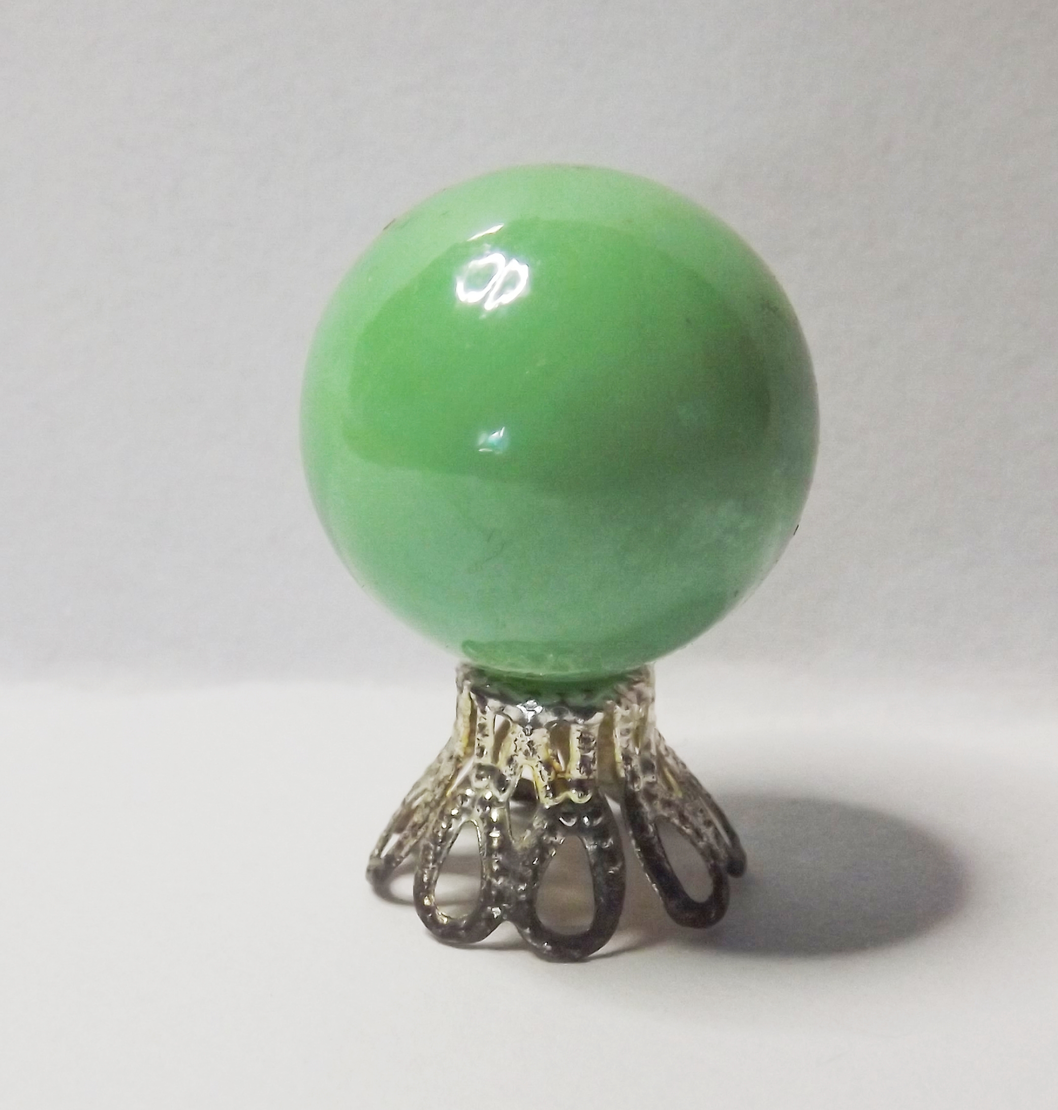 OPAQUE GREEN CRYSTAL BALL ON STAND